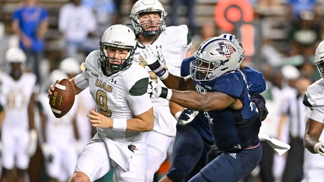 The UAB quarterback is pursued by a Rice defender during their football game Oct. 1 at Rice Stadium. The photo was taken by Maria Lysaker for Rice Athletics.