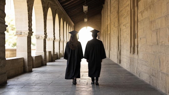 two people in graduation caps and gowns walking