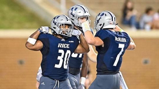 Rice football players flex while celebrating during their victory over Louisiana at Rice Stadium.