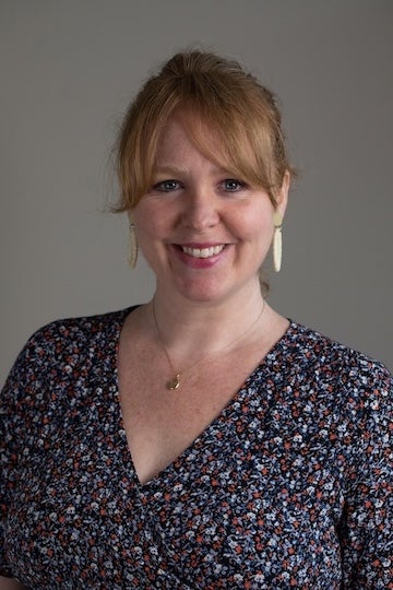 A white woman smiles at the camera