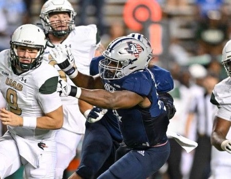 The UAB quarterback is pursued by a Rice defender in their football game Oct. 1 at Rice Stadium.