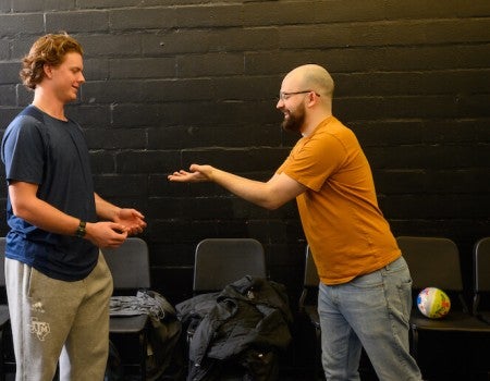 Student on left participating in acting exercise with professional actor on right