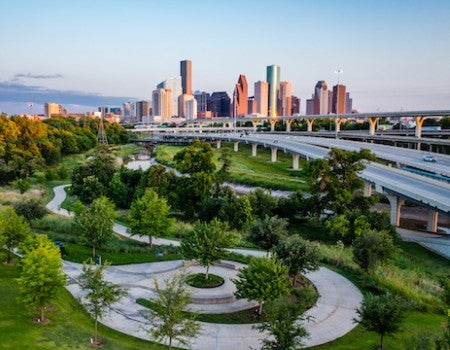 Photo of White Oak Bayou with Houston skyline in the background.