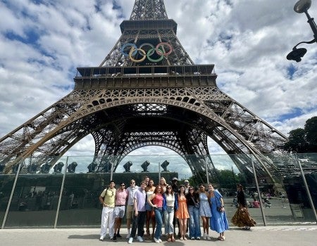 Rice sport management students posing underneath the Eiffel Tower in Paris.