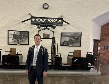 A man wearing a suit poses for a photo inside the Capitol.