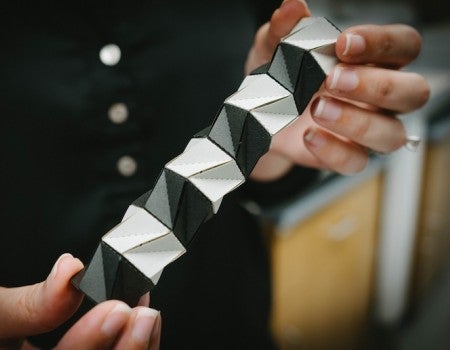 Larissa Novelino holds an origami structure