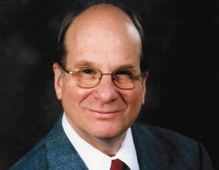 Photo of Louis Brus, a smiling older white man with glasses