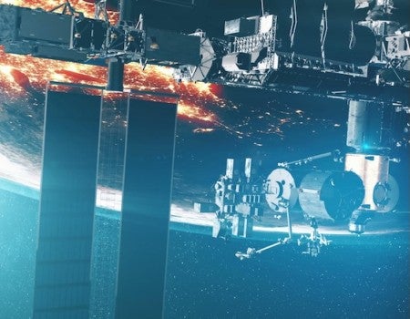 A close-up of a satellite orbiting the Earth, passing over a city. 