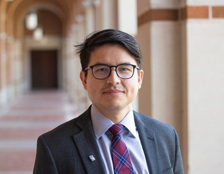 landscape orientation photo of man wearing a suit and tie looking at the camera