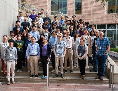 A group of people stand on an outdoor stairwell. 