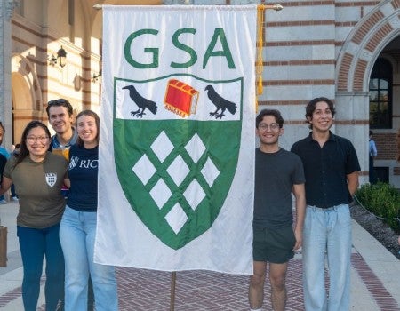 graduate students holding a GSA banner in front of Lovett Hall