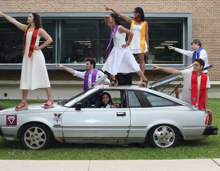 students posing with car