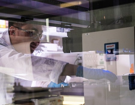 researcher interacting with lab equipment