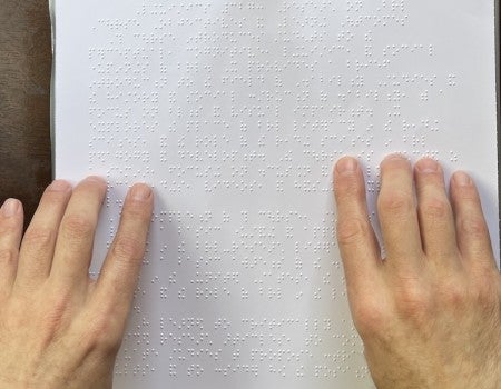 Robert Englebreston reading braille. 