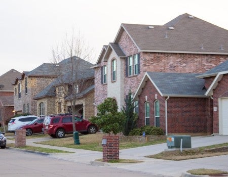 Suburban street with rows of brick homes. 