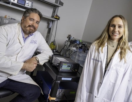A man and a woman are in a lab and wearing lab coats. 