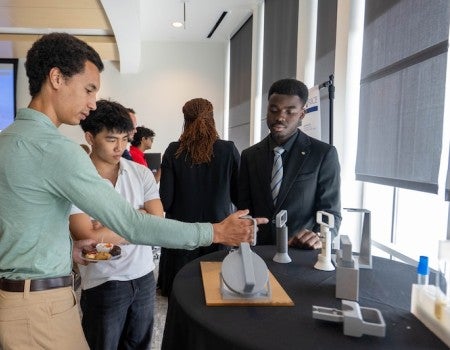 Students from the SEED program show off their designs. 