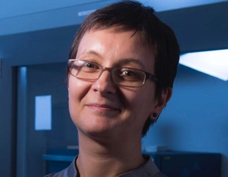A white woman smiles at the camera