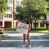 Sid Richardson College students welcome new freshmen with handmade signs. (Photo by Tommy LaVergne)