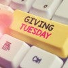 Finger pressing a Giving Tuesday key