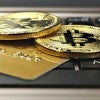 Bitcoin coins and a credit card on top of a computer