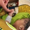 Caregiver touching newborn baby's hand