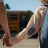 Photo of student and parent holding hands.