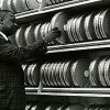Computer specialist John Smith arranges and examines cannisters of magnetic tape used in the processing of medical data at the National Library of Medicine