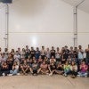 A group of about 30 Fulbright recipients and Rice administrators pose for a photo in the Grad Bubble making the "owls up" sympbol.