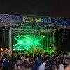 A picture of the Moody Fest stage and all the attendees listing to music and waving glow sticks.