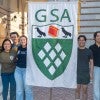 graduate students holding a GSA banner in front of Lovett Hall
