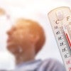 stock image featuring thermometer showing high temps and man pouring water bottle over his head 