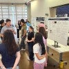 poster presentation session with students listening to a presenter 