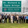 A group of people stand under a sign that reads Dr. Richard A. Tapia Bridge 