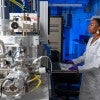 black female researcher in lab coat interacts with research equipment