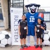 Two campers stand next to Sammy the Owl outside Rice Stadium 
