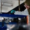 researcher in lab coat interacting with equipment 
