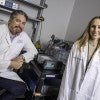 A man and a woman are in a lab and wearing lab coats. 