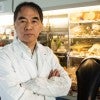 An Asian man in a lab looks at the camera