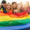 A group holds a Pride flag. 